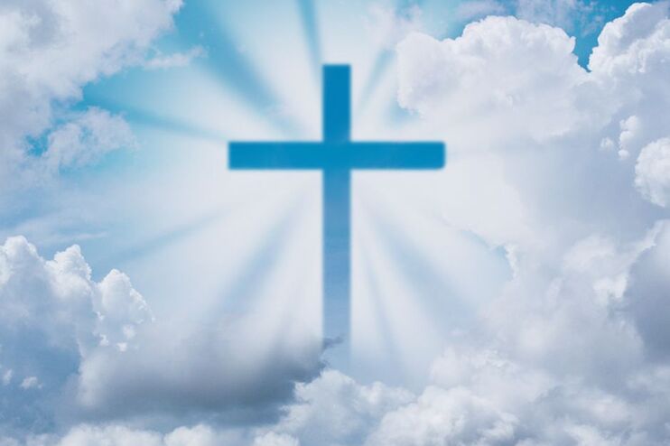 Wolken bilden ein Kreuz, das von weißen Strahlen umrahmt ist.