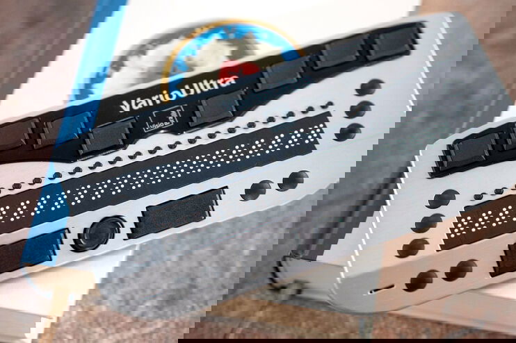 Ein kleines Gerät mit Braille-Punkten liegt auf einer Bibel.