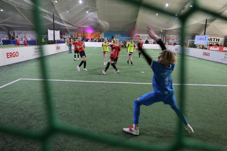 Szene bei einem Fußball-Spiel mit jungen Menschen: der Torhüter kann den Ball nicht mehr erreichen.