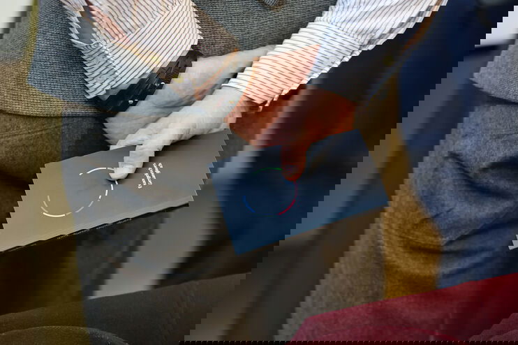 Jemand hält ein Erprobungsgesangbuch hinter dem Rücken in den Händen