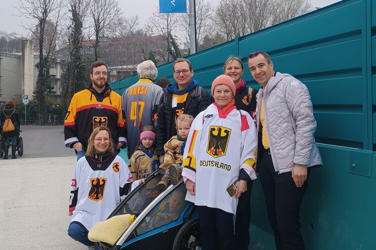 Mehrere Menschen in Deutschland-Trikots stehen für ein Gruppenbild zusammen.