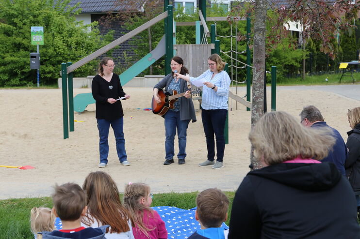 Menschen musizieren auf einem Spielplatz.