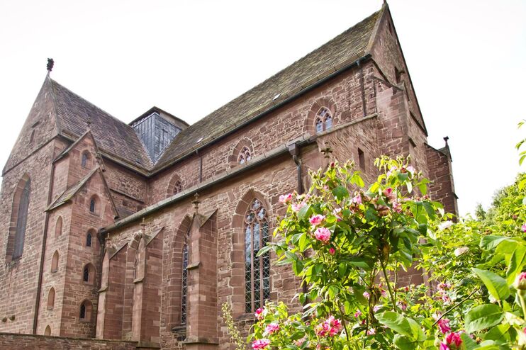 Eine Kirche hinter einem Rosenbusch.