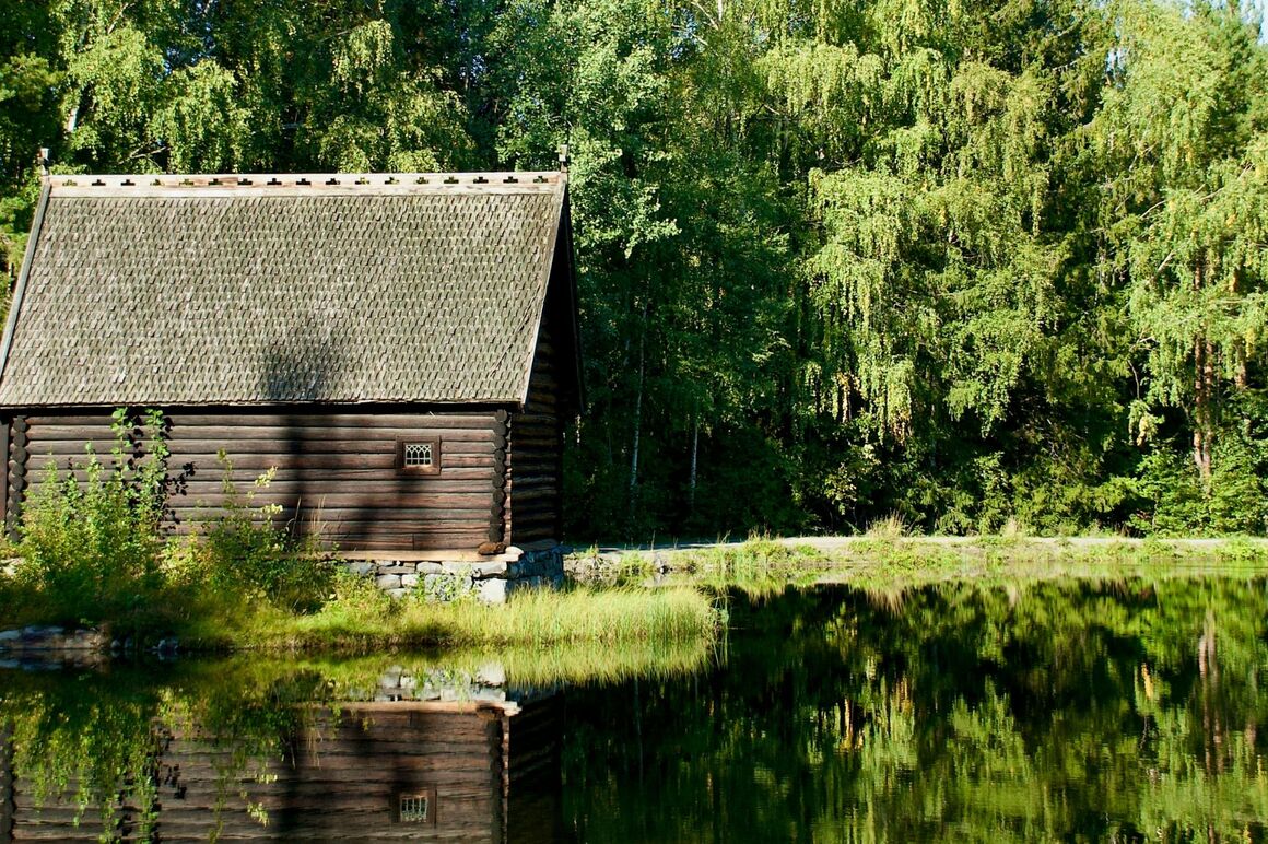 Eine kleine Hütte am Waldrand an einem See