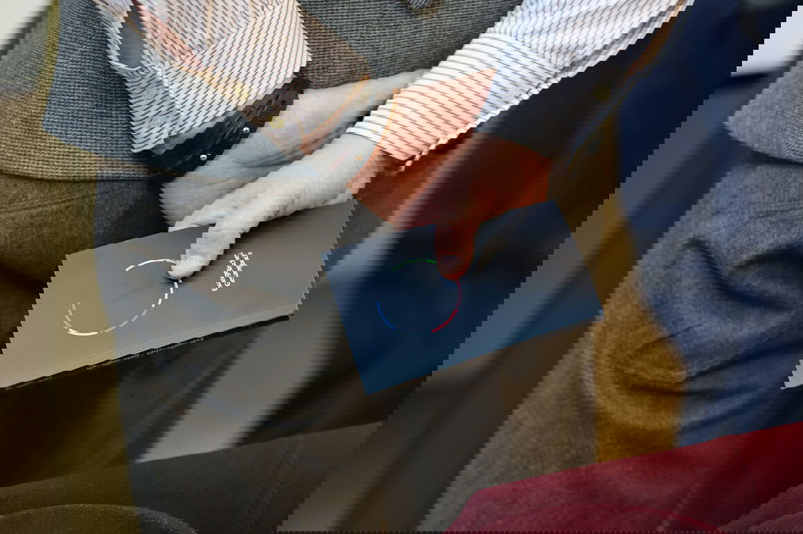 Jemand hält ein Erprobungsgesangbuch hinter dem Rücken in den Händen